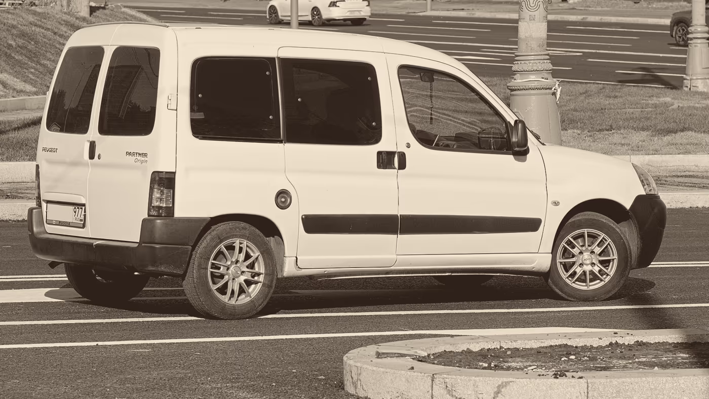 Peugeot Partner blanco visto de perfil, estacionado